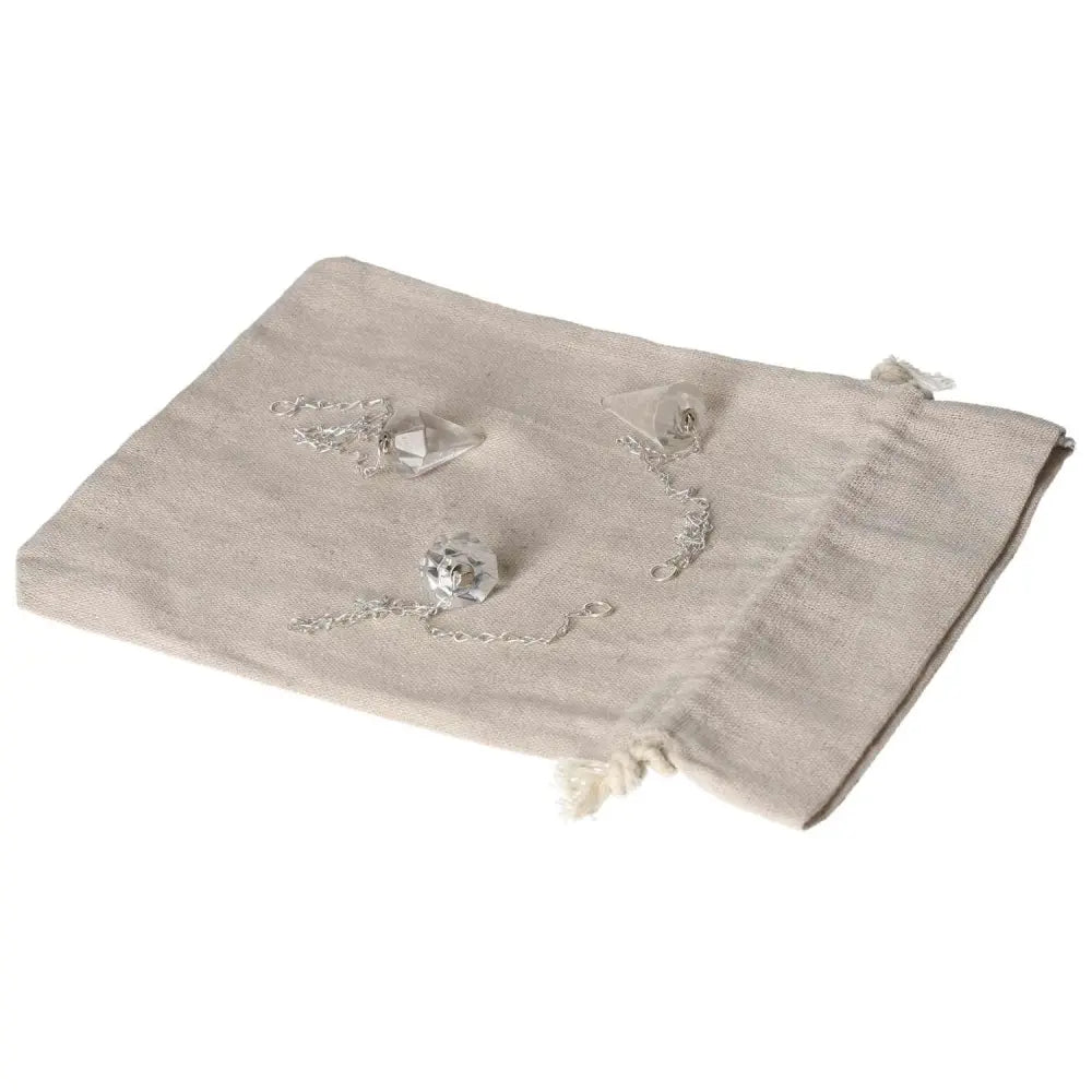 Clear Quartz Pendulum on linen pouch, harmonizes energy and purifies space, ideal for daily use.