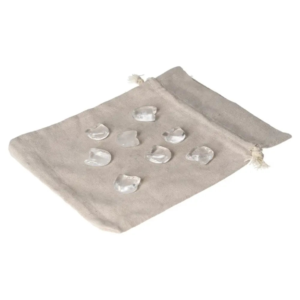 Small clear quartz cat figures on a fabric bag, symbolizing clarity and playful energy for collectors and spiritual seekers.