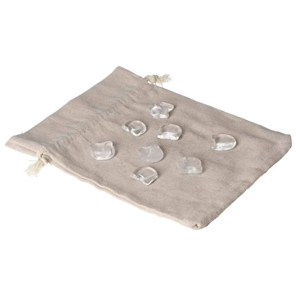 Small clear quartz cat figures on a beige cloth, symbolizing clarity and playful energy, perfect for collectors and spiritual growth.