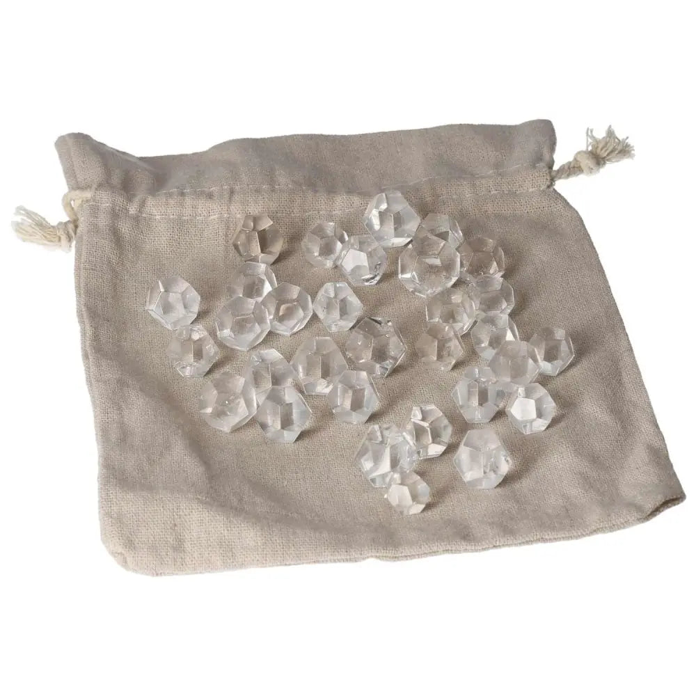 Clear quartz geometric spheres in a beige pouch, ideal for purification and harmonizing energy.