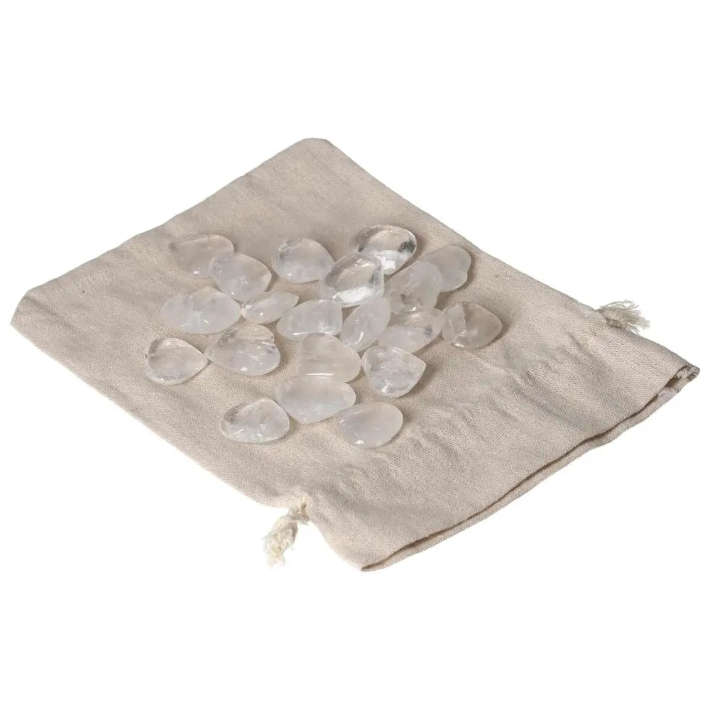 Clear Quartz small hearts on a beige cloth, known for purification and harmonizing energy, against negative vibrations and radiation.