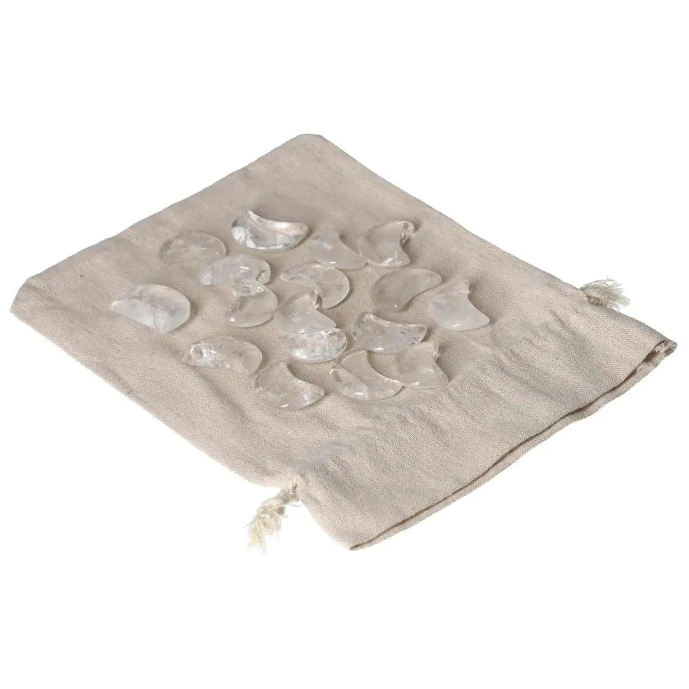 Clear Quartz small moon stones on beige drawstring pouch, ideal for energy purification and harmonizing negative vibrations.