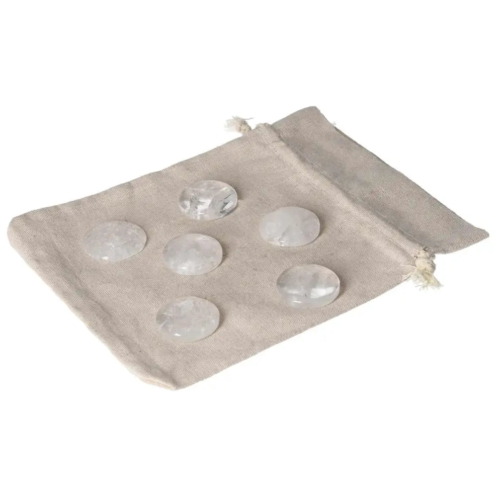 Set of clear quartz palmstones on a beige cloth pouch, ideal for purification and harmonizing energy.