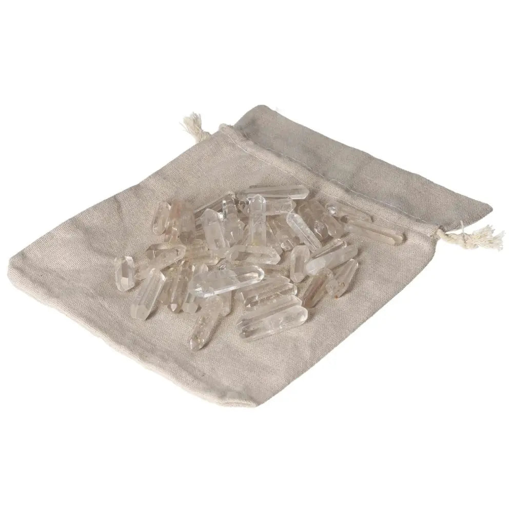 Clear Quartz Small Stics on a beige drawstring bag for energy purification and harmonization.
