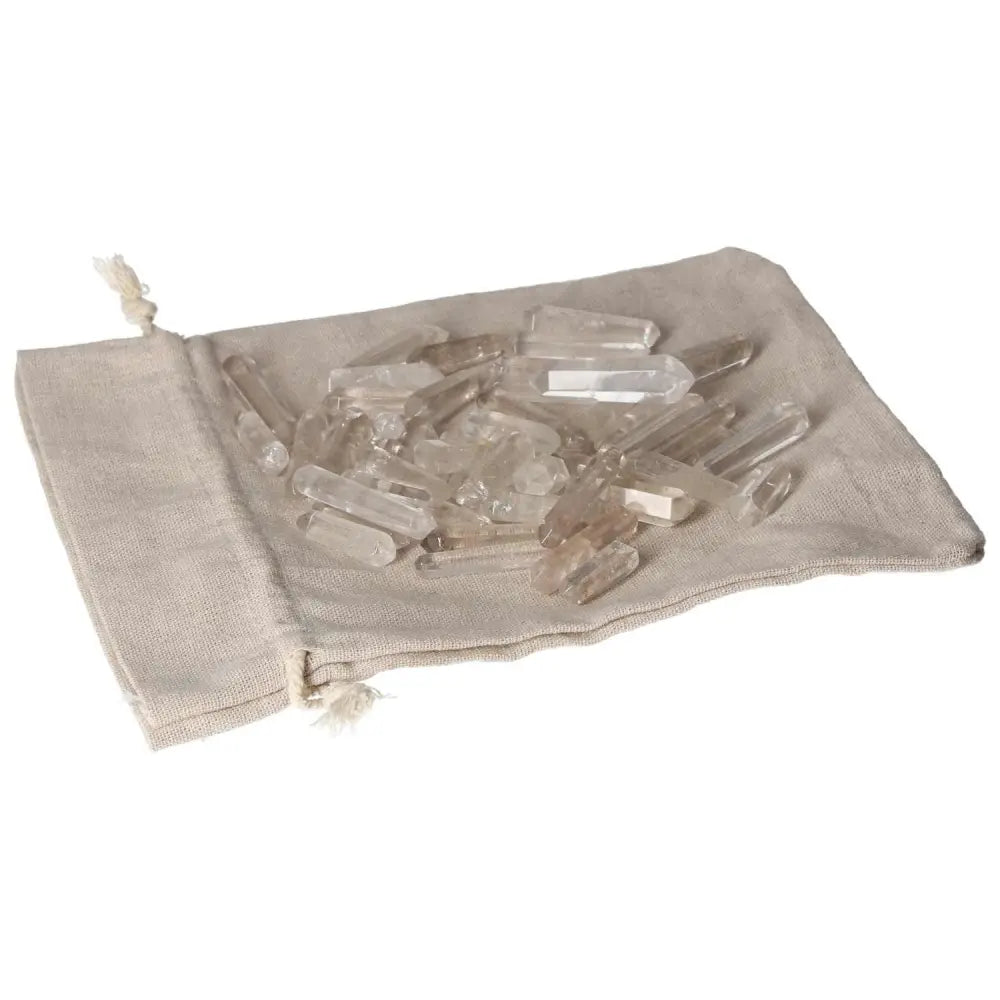 Small clear quartz sticks on a beige cloth bag for purification and harmonizing negative energy.