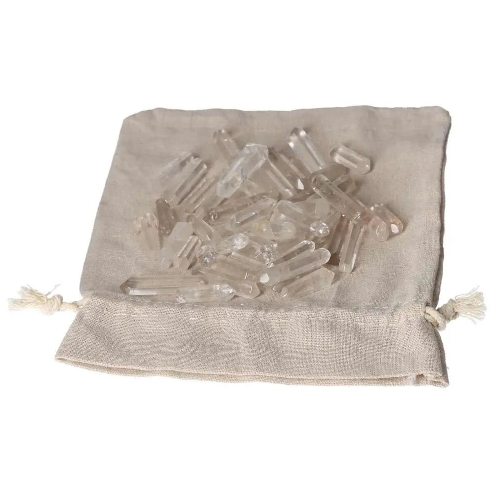 Clear Quartz small sticks on a beige cloth bag for purification and energy harmonizing.
