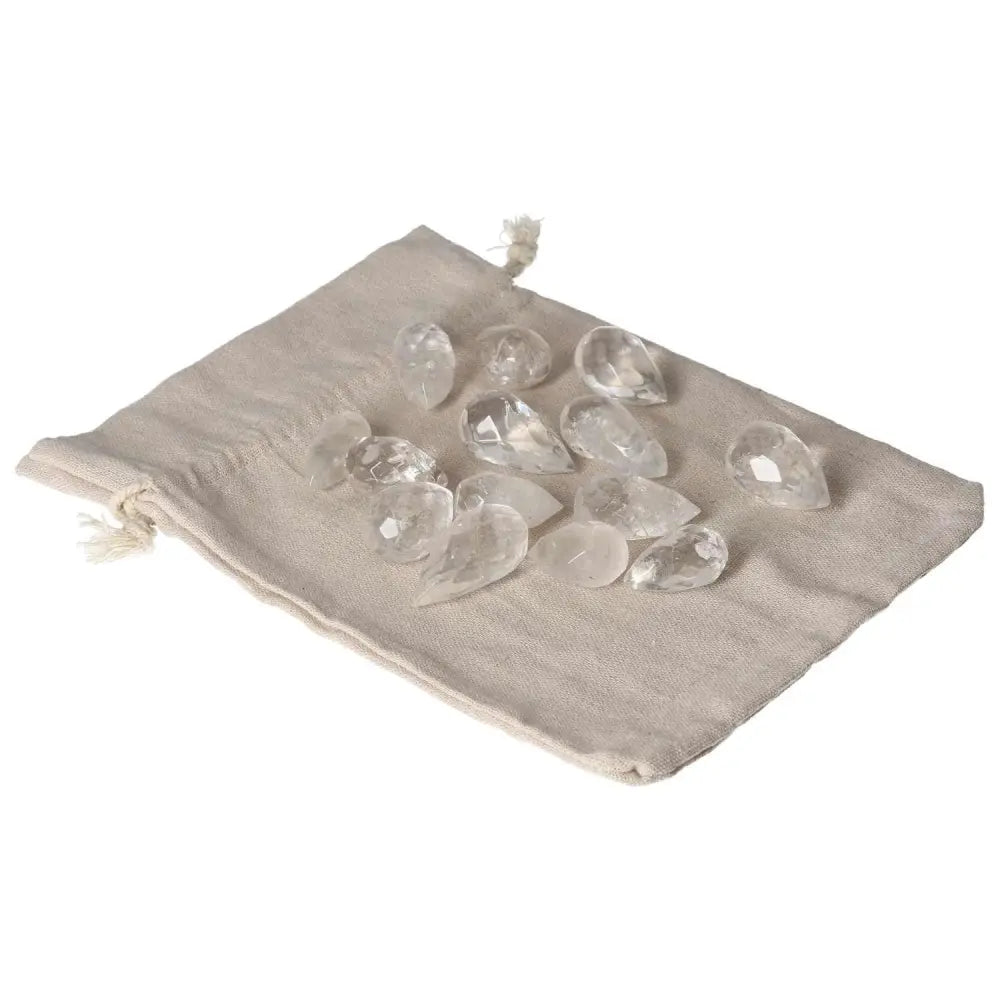 Clear Quartz small tear-shaped crystals on a beige pouch, ideal for purification and energy harmonization.
