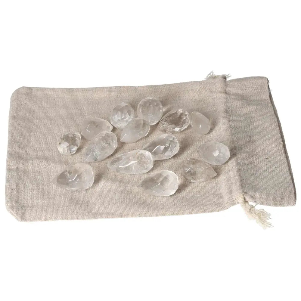 Clear Quartz Small Tear stones on a beige fabric pouch for purification and energy balancing.