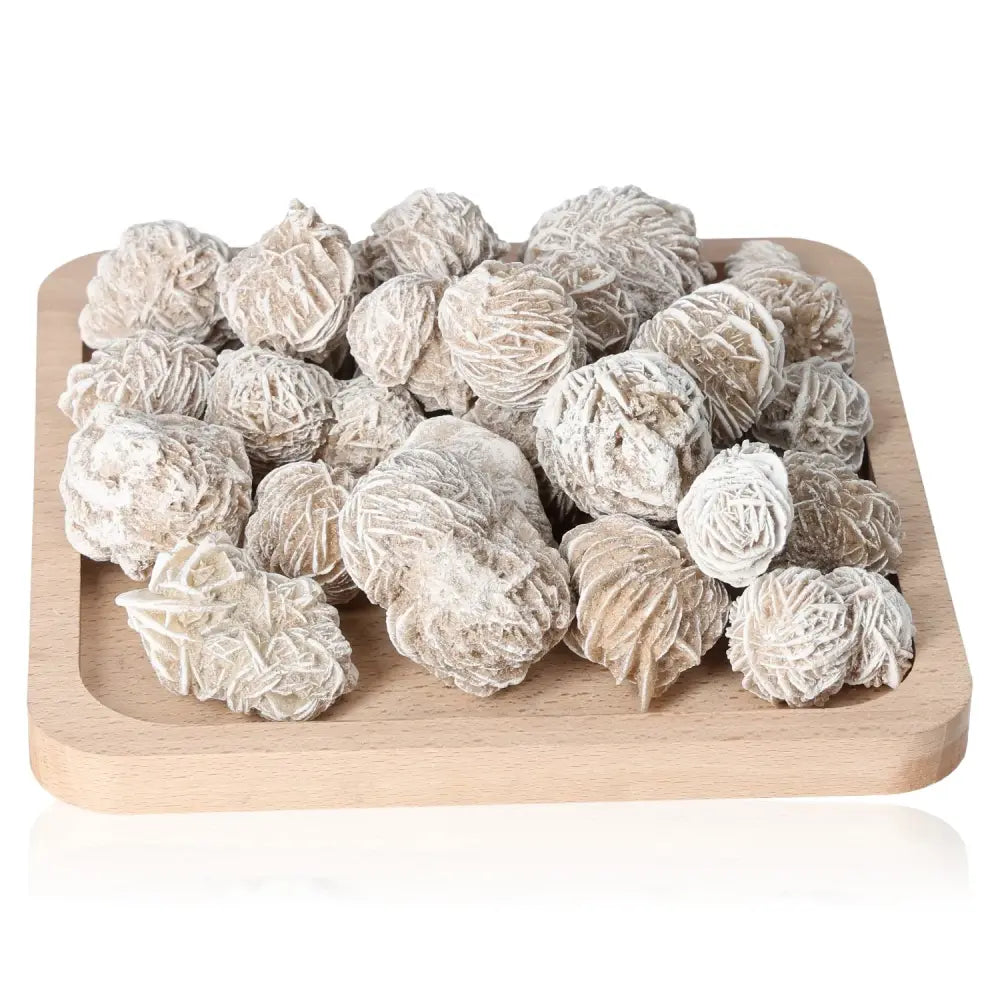 Ethically sourced Desert Rose crystals on a wooden tray from Sylvia Crystals, showcasing nature's sculptural beauty.