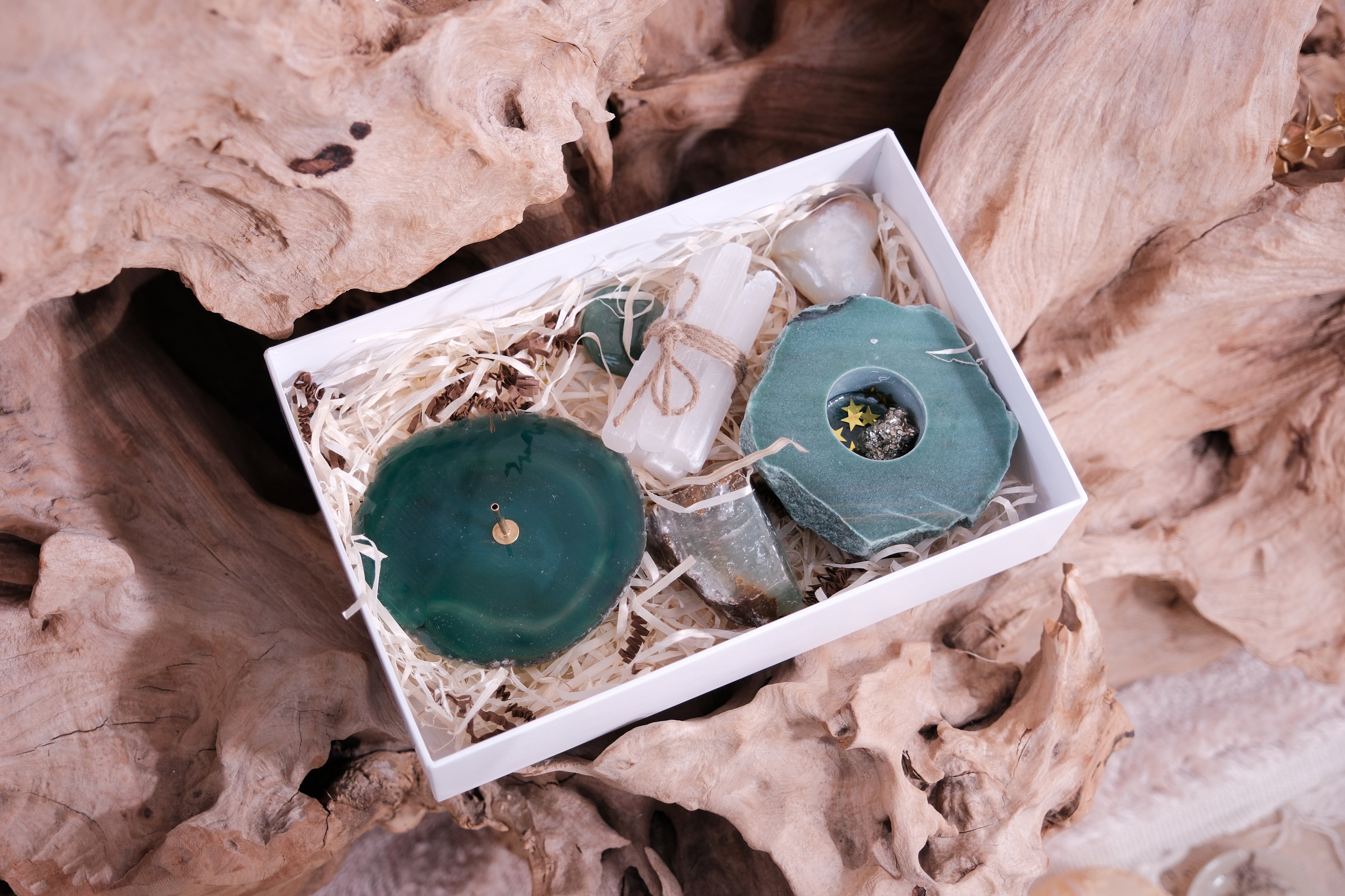 Christmas Gift Box with crystals and spiritual tools for balance and tranquility on natural wood background.