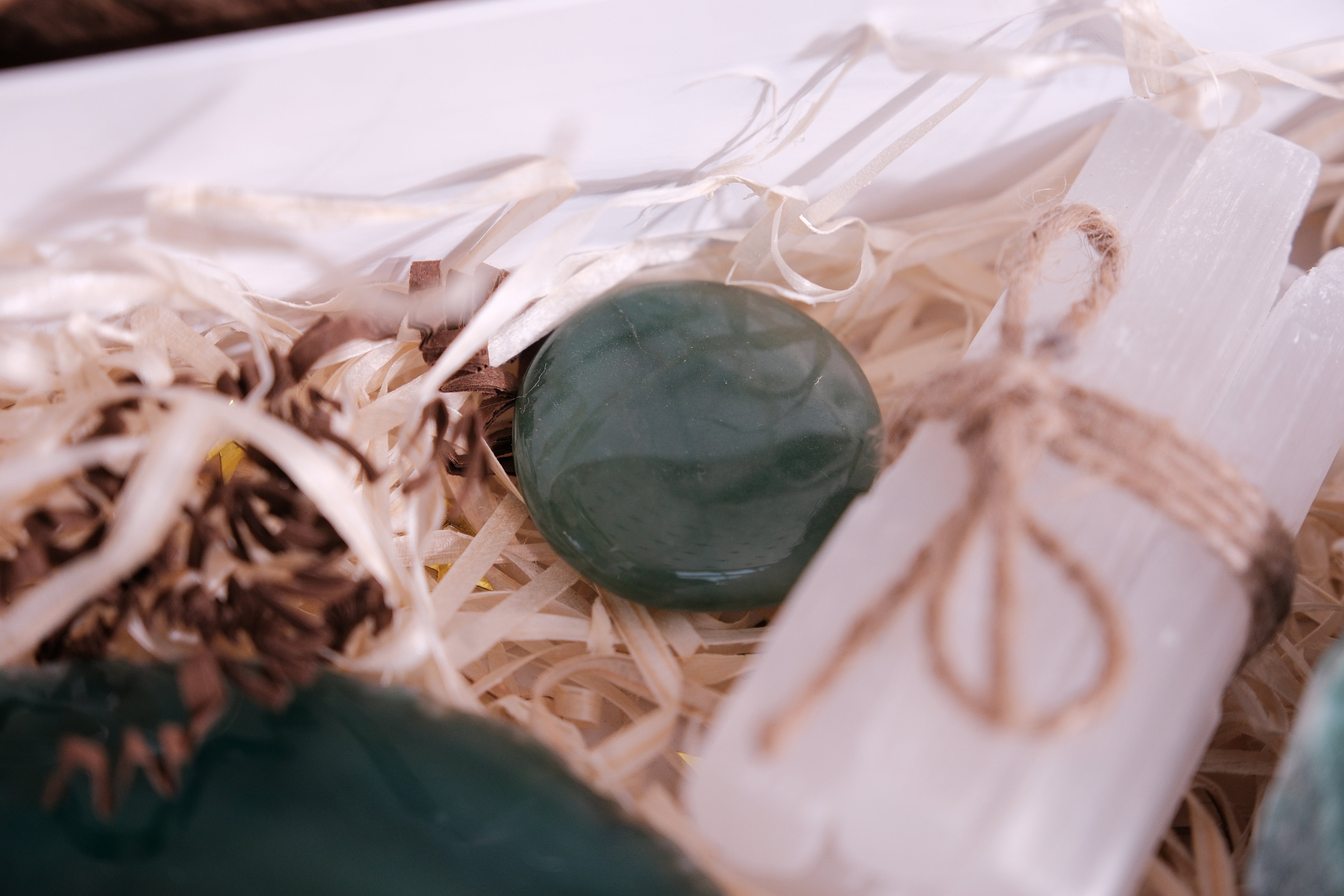 Christmas gift box with crystals and spiritual tools for balance and tranquility, featuring green stone and selenite wand.