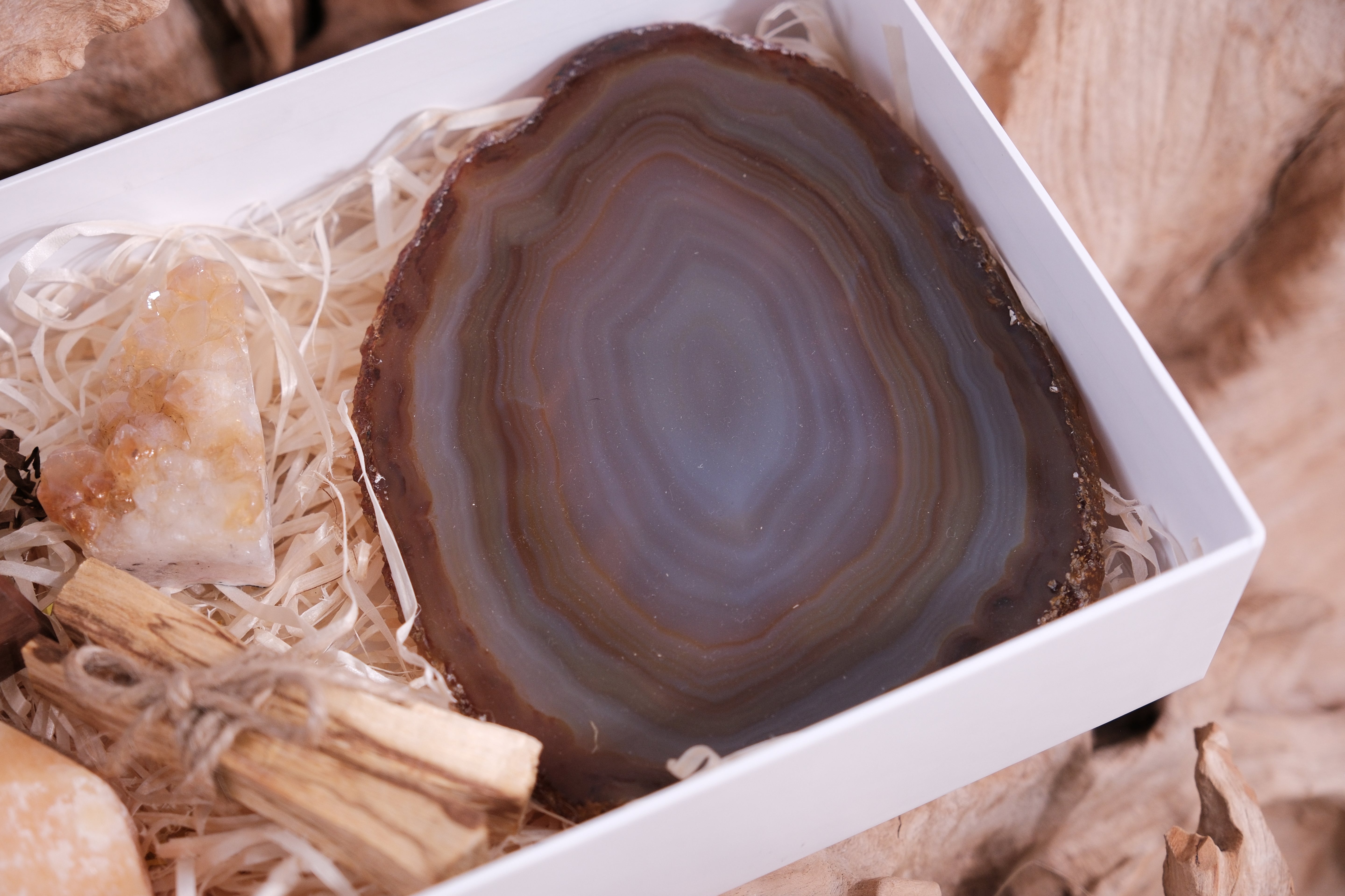 Sylvia Crystals Gift Box containing an agate slice and other crystals, showcasing natural beauty and positive energy.