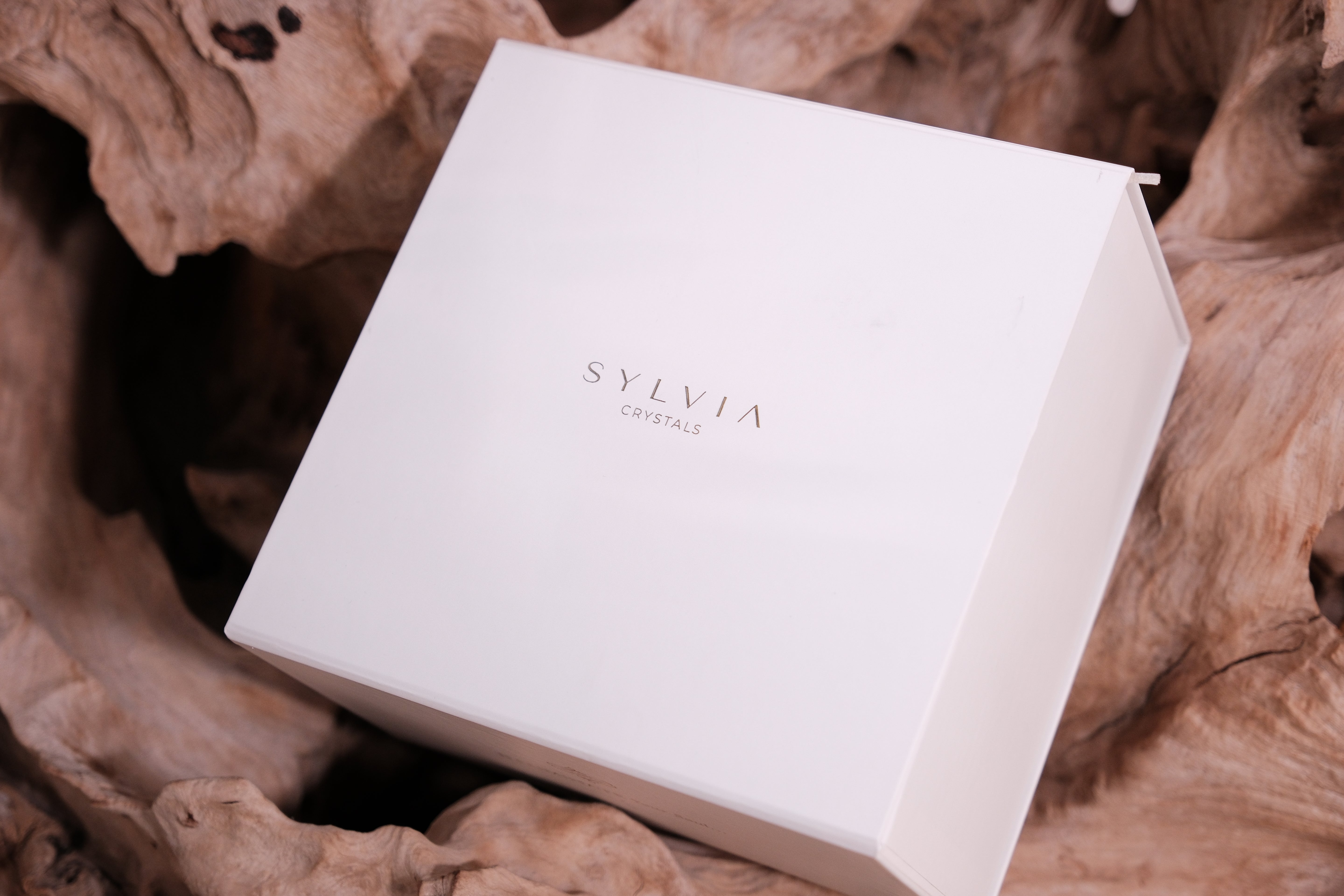 Elegant white Sylvia Crystals deluxe gift box on natural wood background, perfect for Christmas gifts, featuring exquisite crystals.