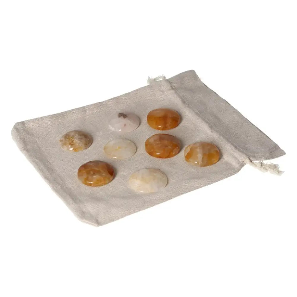 Golden Healer Small Palmstone collection displayed on a cloth, showcasing their natural healing properties and vibrant colors.