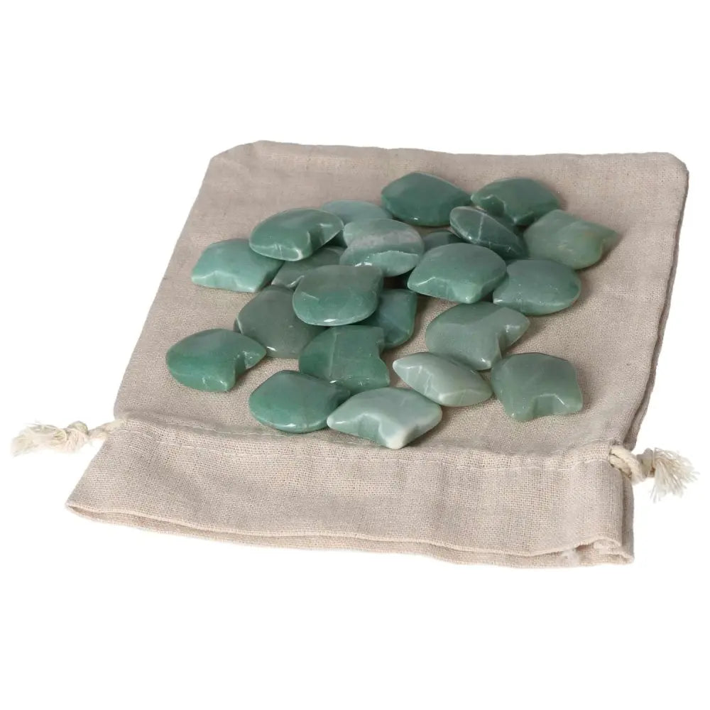 Polished green aventurine stones on a beige cloth bag, promoting luck, prosperity, and inner peace.