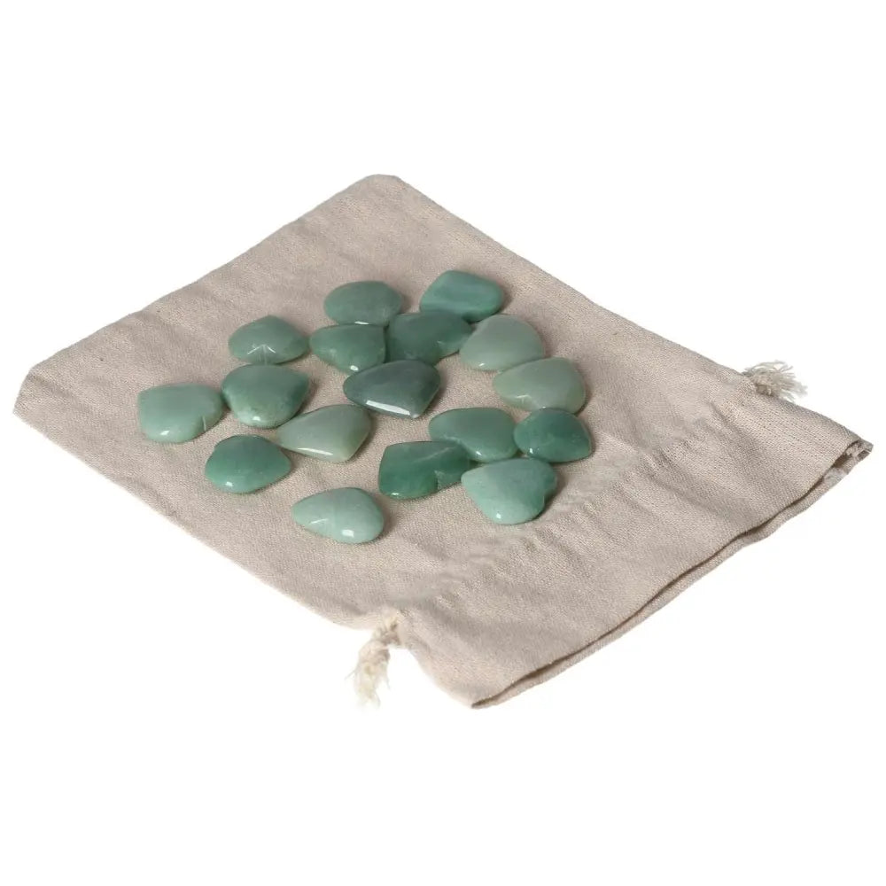 Polished green aventurine stones on a beige cloth, promoting prosperity and inner peace.