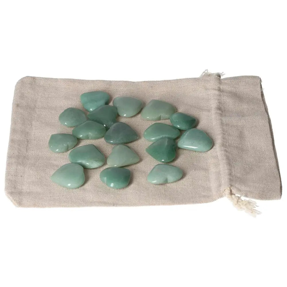 Green Aventurine small heart stones on a beige pouch, symbolizing luck and self-confidence, ideal for new beginnings and harmony.