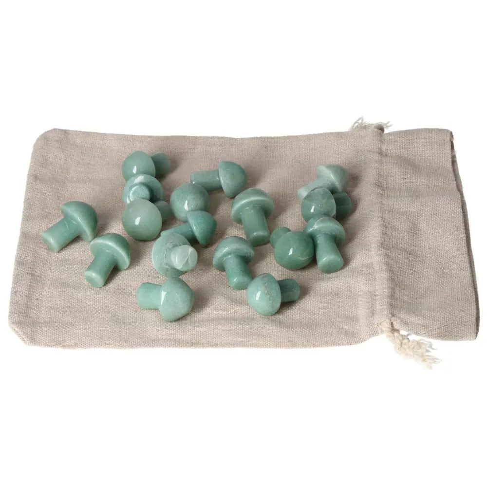 Green Aventurine small mushroom stones on a beige cloth, symbolizing new beginnings and self-confidence, perfect for luck and harmony.