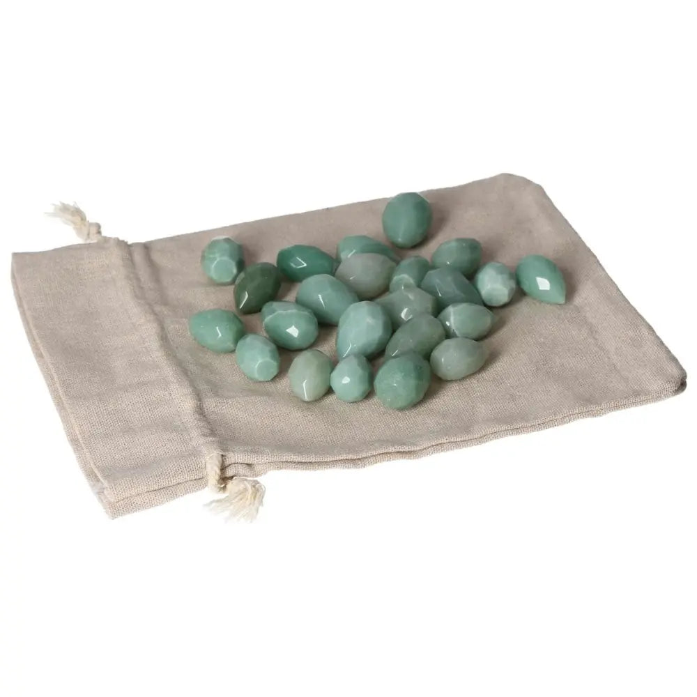 Small Green Aventurine stones on a beige pouch, promoting self-confidence and inner peace, ideal for new ventures and harmony.