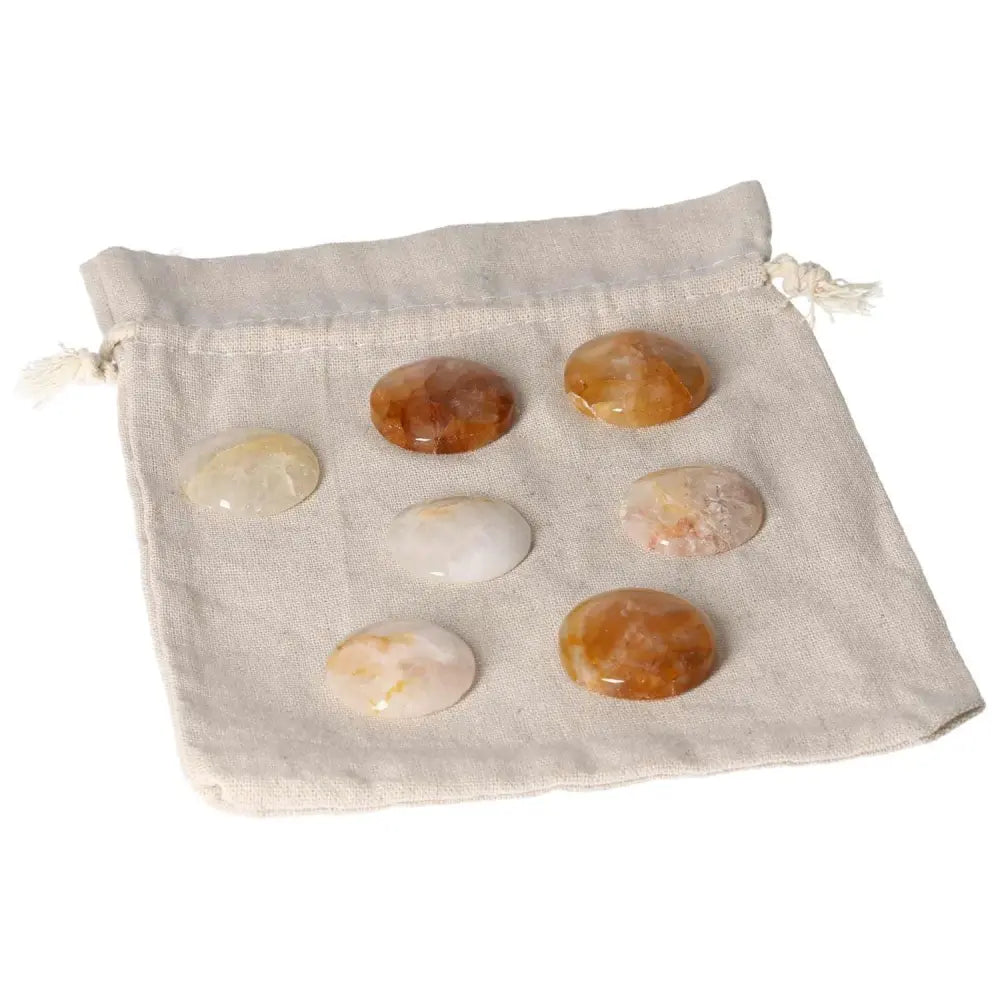 Six Hematoid Quartz palmstones on a soft drawstring bag, ideal for emotional balance, clarity, and grounding energy.