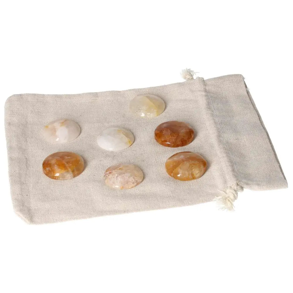 Hematoid Quartz palmstone set on beige pouch for grounding and emotional balance