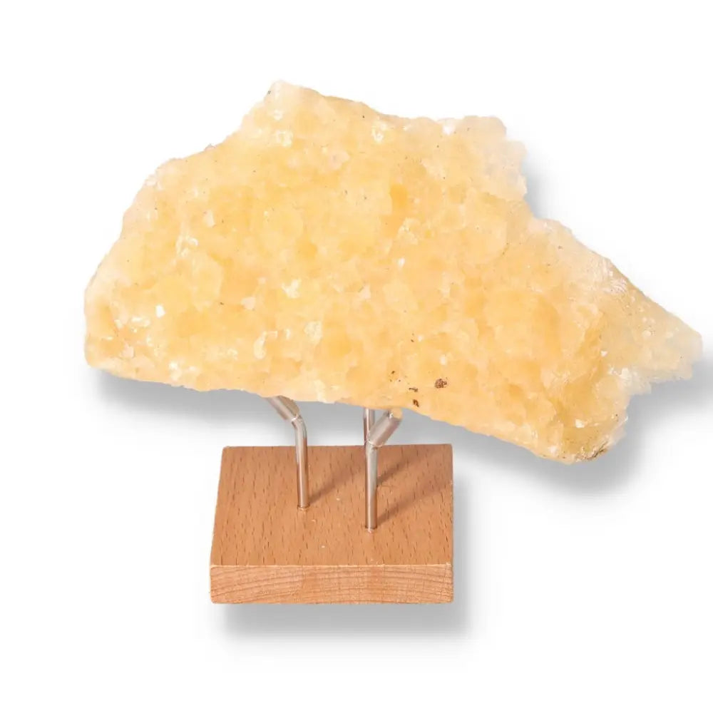 Honey Calcite gemstone on stand, known for boosting confidence and clarity, aligns with solar plexus and sacral chakras.