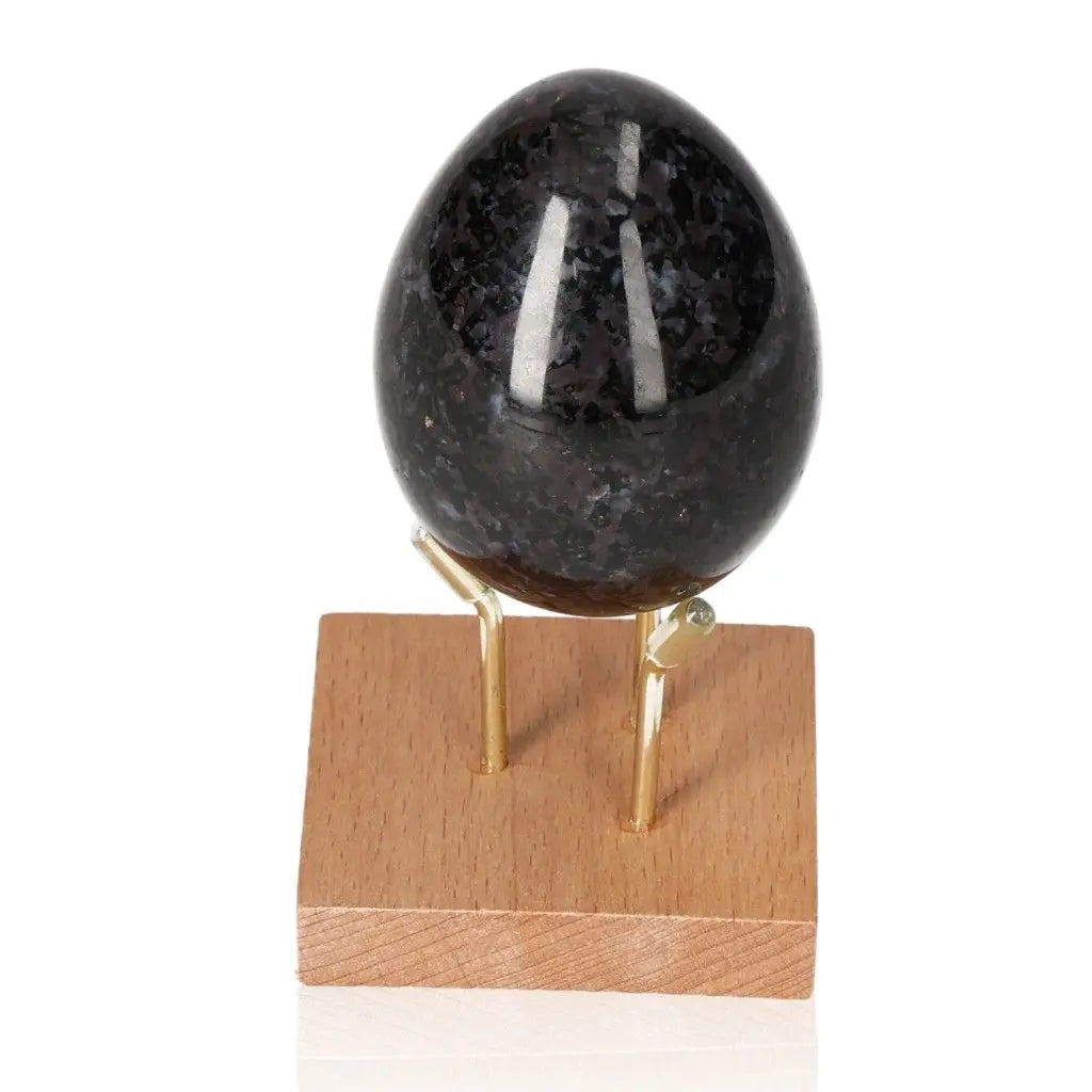Indigo Gabbro Egg on stand, showcasing swirling black and indigo patterns, known for its intuitive and spiritual growth properties.