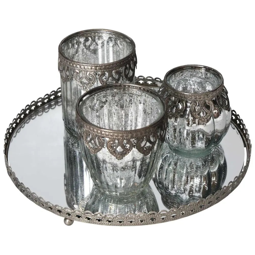 Elegant lantern set on mirror tray with silver metal rim, perfect for adding luxury and elegance to any space.