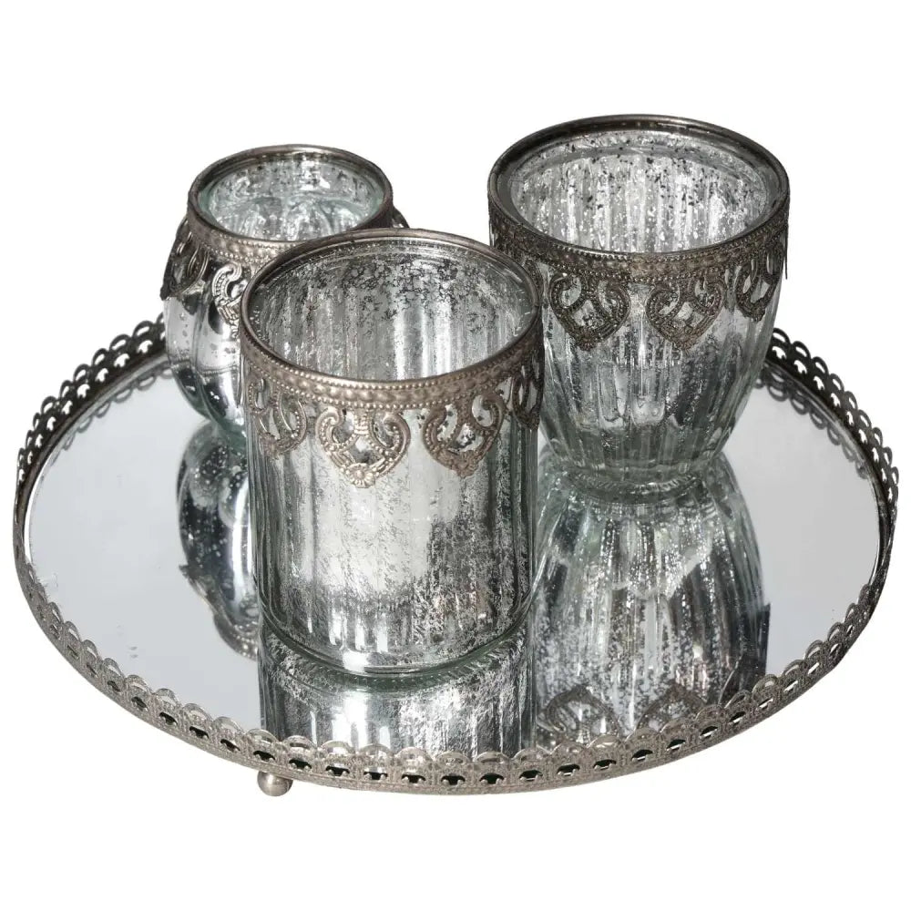 Lantern set on mirror tray with silver metal rim, showcasing elegant craftsmanship and reflective design for luxurious home decor.