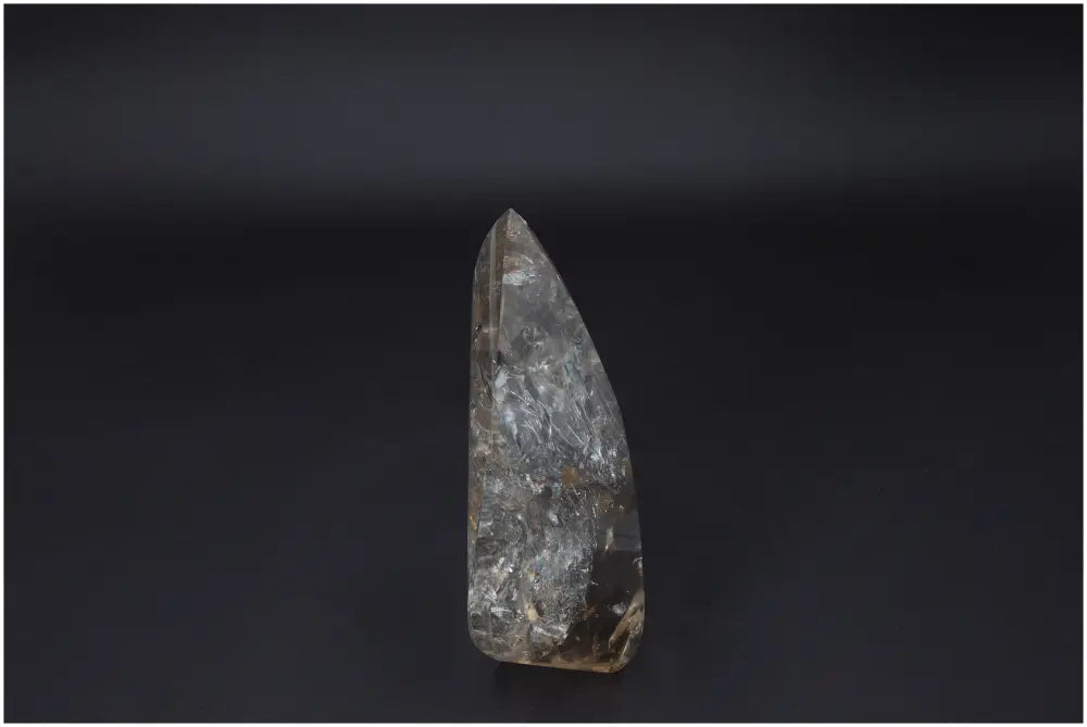 Large Lemurian Quartz Obelisk on dark background, showcasing its natural clarity and healing properties.