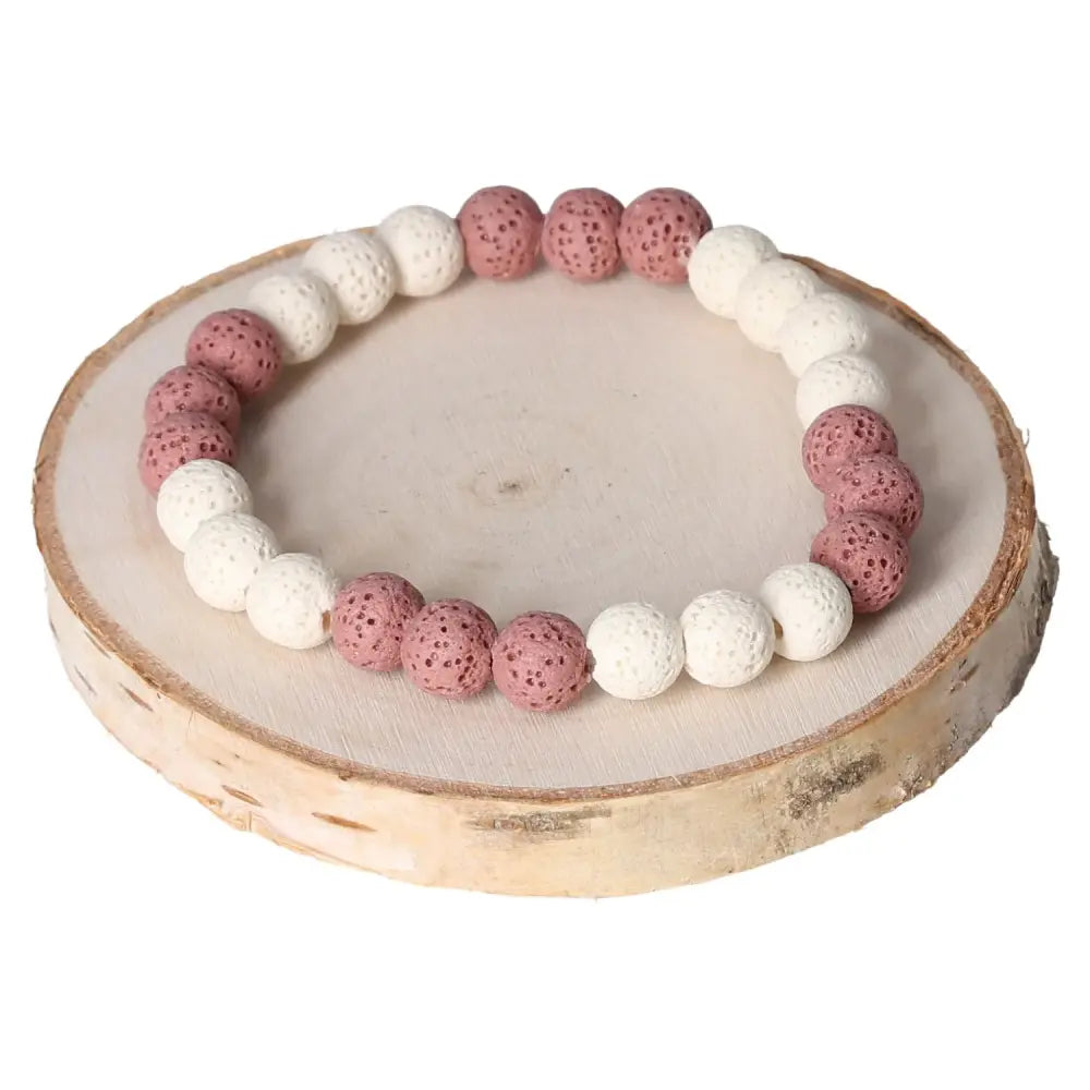 Lava Bracelet 8mm featuring pink and white volcanic beads, elegantly displayed on a wooden surface.