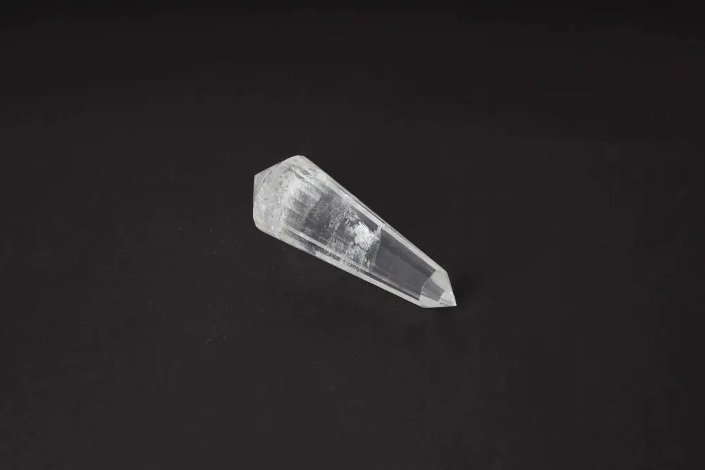 Lemurian Quartz Point crystal with horizontal striations on a dark background, symbolizing ancient wisdom and spiritual energy.
