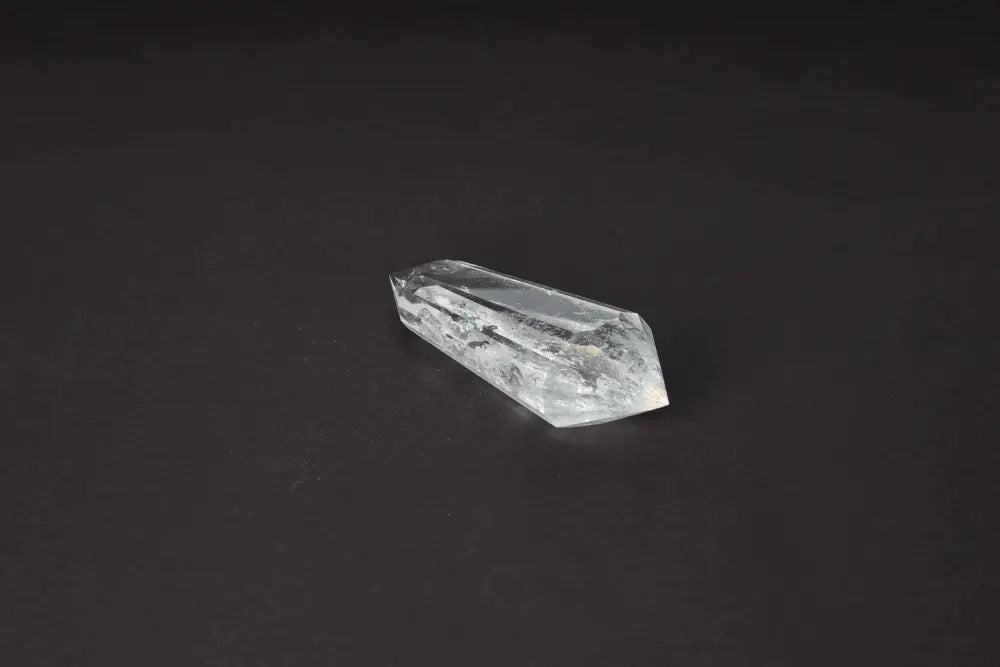 Lemurian Quartz Point crystal on a dark background, showcasing its unique horizontal striations and ancient, mystical appearance.