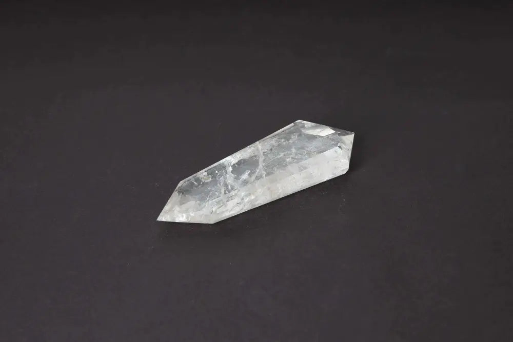 Lemurian Quartz Point crystal with horizontal striations on dark background, symbolizing ancient wisdom and spiritual connection.