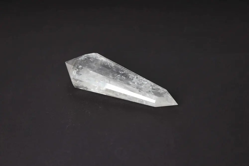 Lemurian Quartz Point crystal with distinct horizontal striations on dark background, embodying ancient wisdom and spiritual energy.