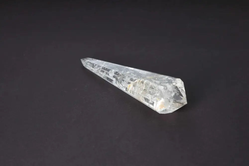 Lemurian Quartz Point crystal with horizontal striations symbolizing ancient wisdom on a dark background.