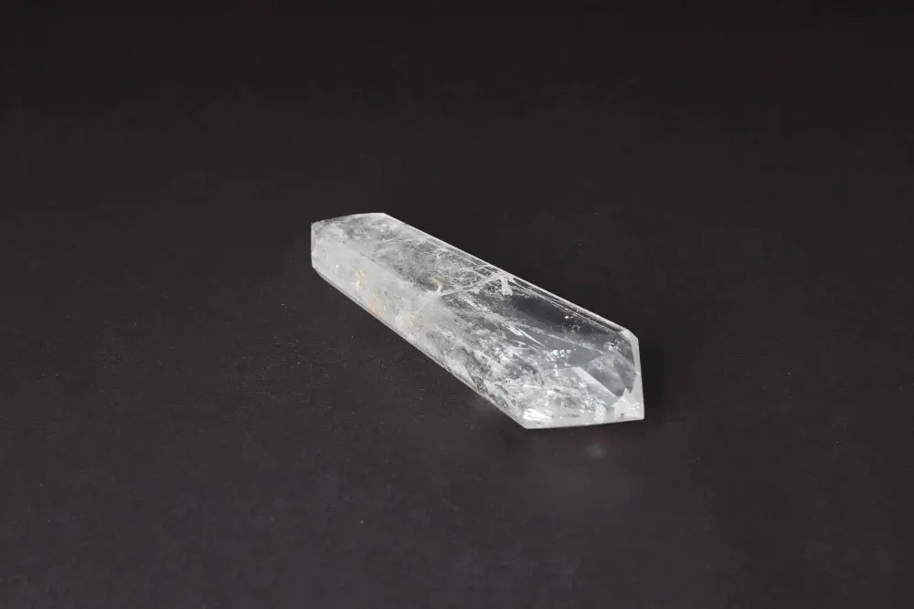 Lemurian Quartz Point crystal with horizontal striations on a dark background, symbolizing ancient wisdom and spiritual energies.