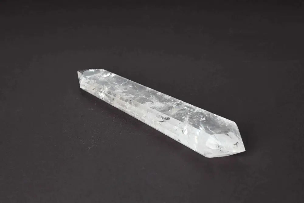 Lemurian Quartz Point with distinct striations, believed to hold ancient wisdom from a mythical civilization on a dark background.