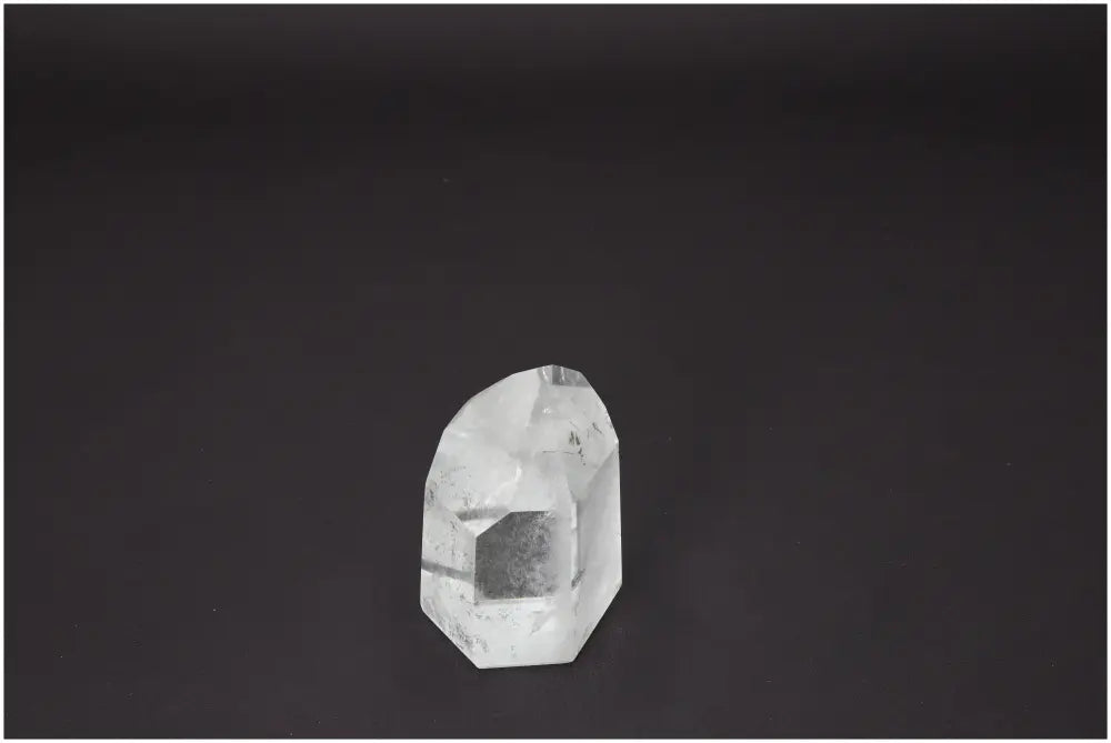 Lemurian Quartz Obelisk from Sylvia Crystals displayed against a dark background, showcasing its clarity and artisanal craftsmanship.