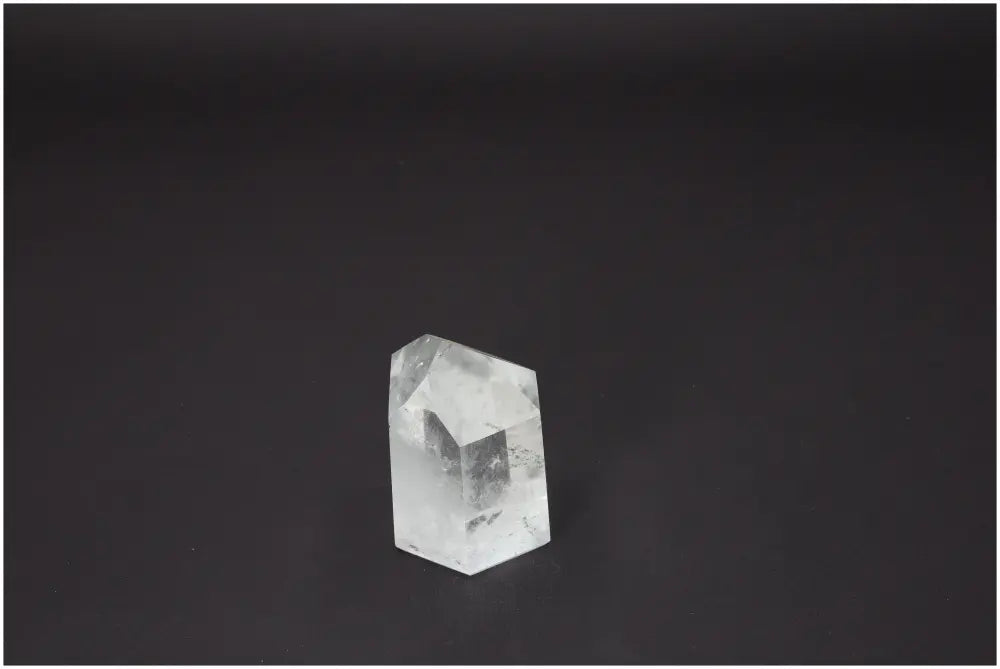 Lemurian Quartz Obelisk on dark background, showcasing its ethereal beauty and spiritual properties, available at Sylvia Crystals.