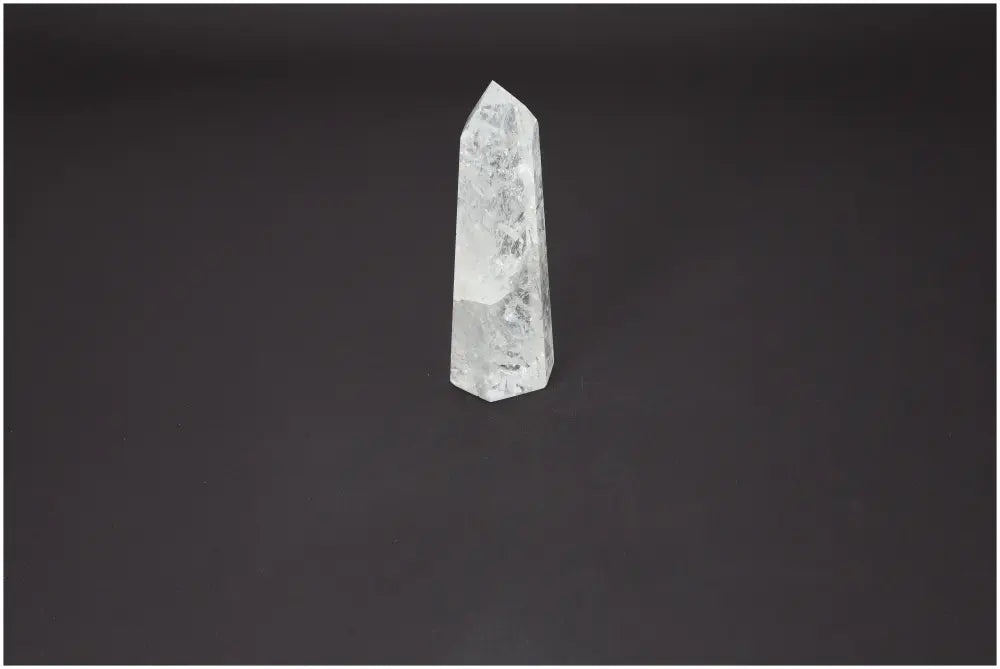 Lemurian Quartz Obelisk by Sylvia Crystals, clear gem for purification and energy harmonization on a dark background.