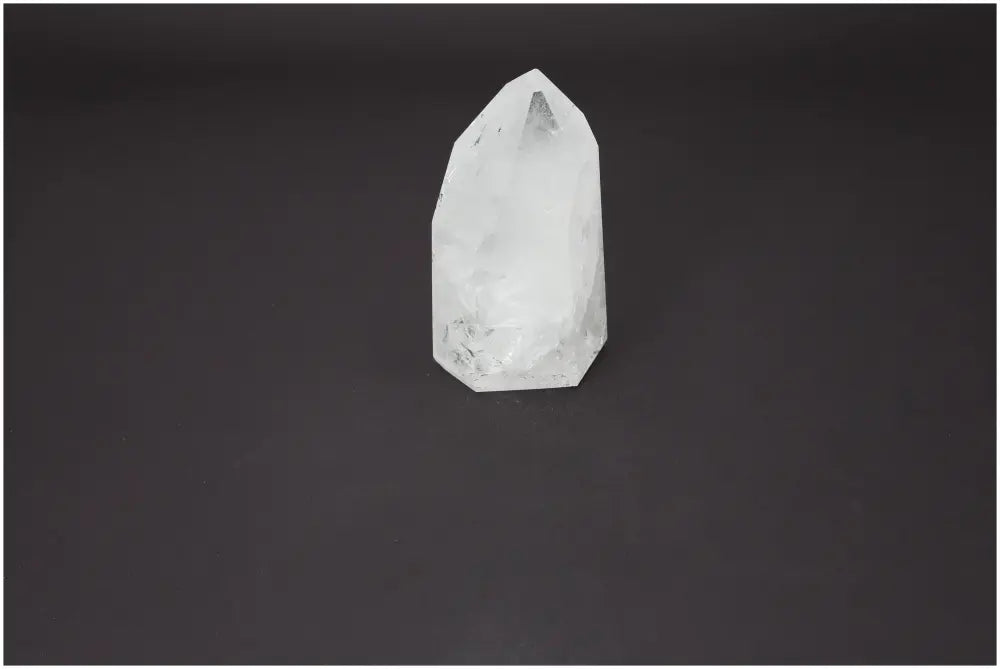 Lemurian Quartz Obelisk from Sylvia Crystals on black background, showcasing its clear design and spiritual qualities.