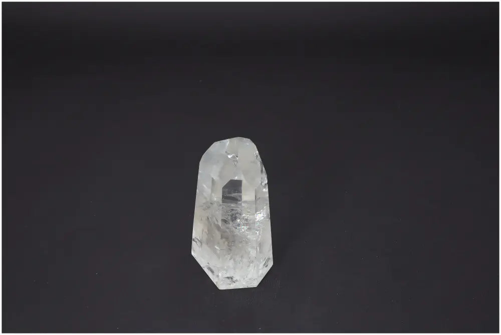 Lemurian Quartz Obelisk against dark background, showcasing unique crystal properties and associations with chakras and zodiac signs.