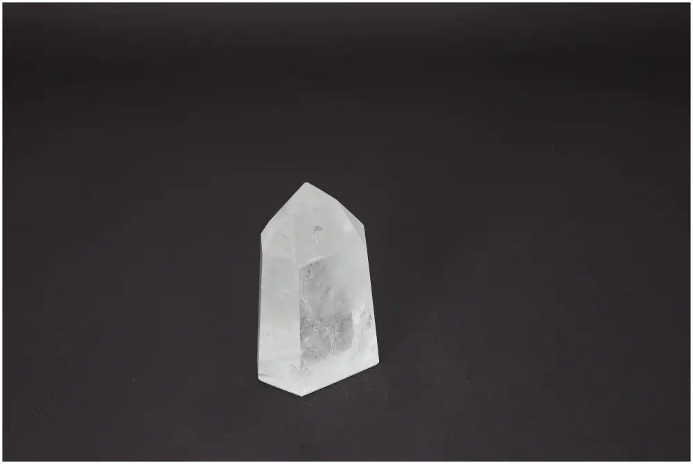 Lemurian Quartz Obelisk on dark background, known for its unique energetic properties, supporting various chakras and zodiac signs.