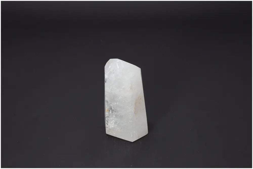 Lemurian Quartz Obelisk against dark background, showcasing distinct clarity and form, associated with chakra and zodiac energies.