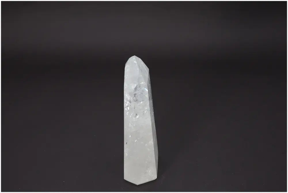 Lemurian Quartz Obelisk on dark background, showcasing its crystalline clarity and spiritual energy properties.