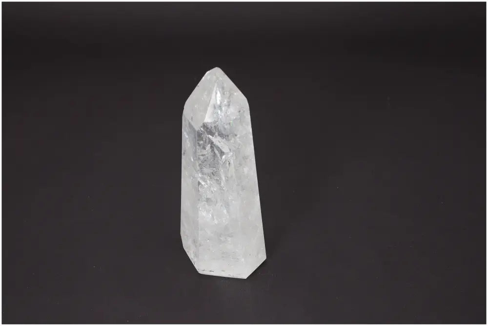 Lemurian quartz obelisk against a dark background showcasing its clear crystalline structure and spiritual properties.