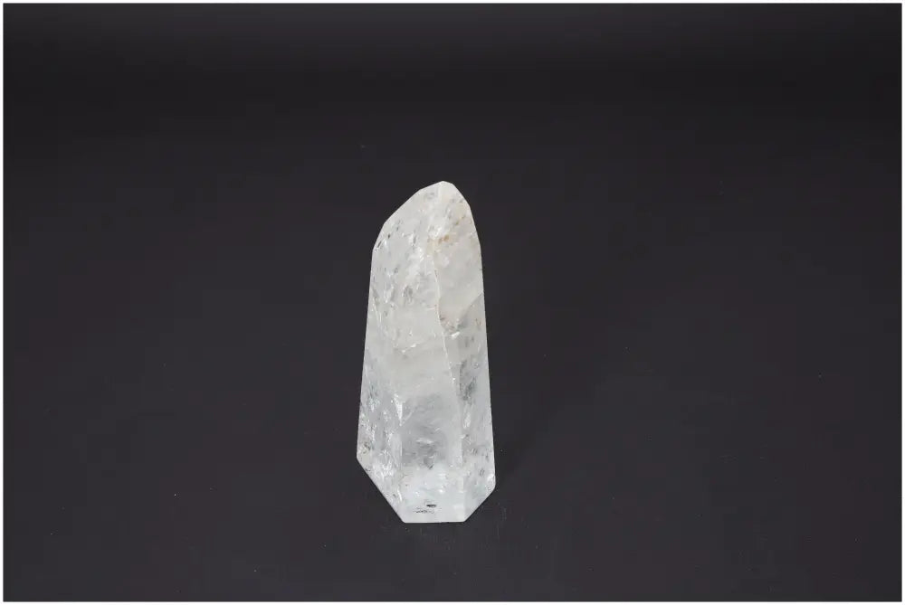 Lemurian Quartz Obelisk against dark background, showcasing crystal clarity and unique properties for chakra and spiritual enhancement.