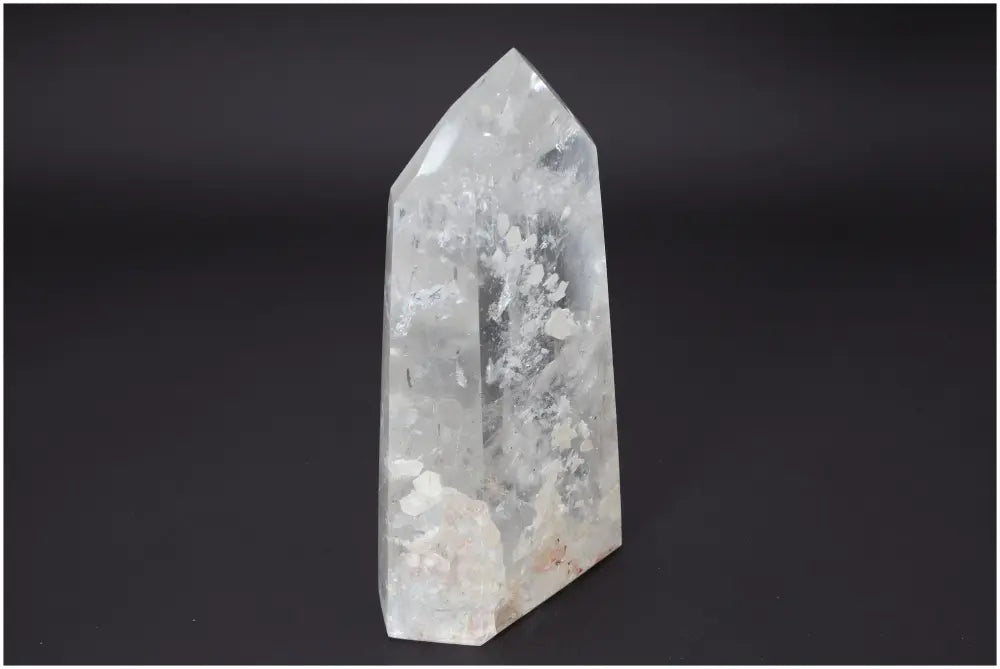 Lemurian Quartz Obelisk on dark background, showcasing its clear crystalline structure and unique spiritual properties for chakra alignment.