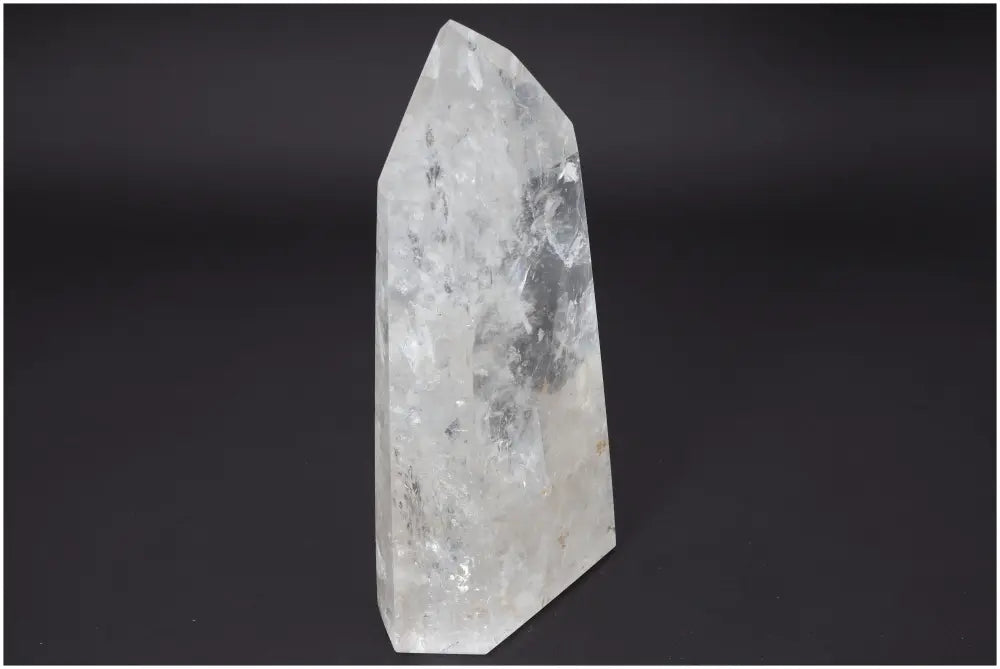 Lemurian Quartz Obelisk standing against a black background, showcasing its clear crystal structure and spiritual properties.